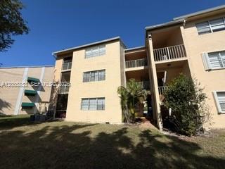 15285 Southwest 107th Lane, Unit 214 Miami, FL 33196 - Photo 14 of 16 a front view of a house with a yard
