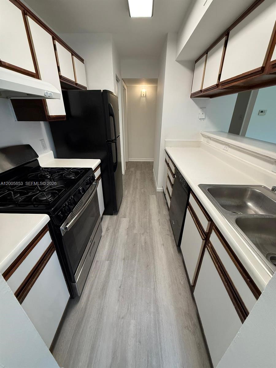 15285 Southwest 107th Lane, Unit 214 Miami, FL 33196 - Photo 3 of 16 a kitchen with stainless steel appliances a stove a sink and a refrigerator