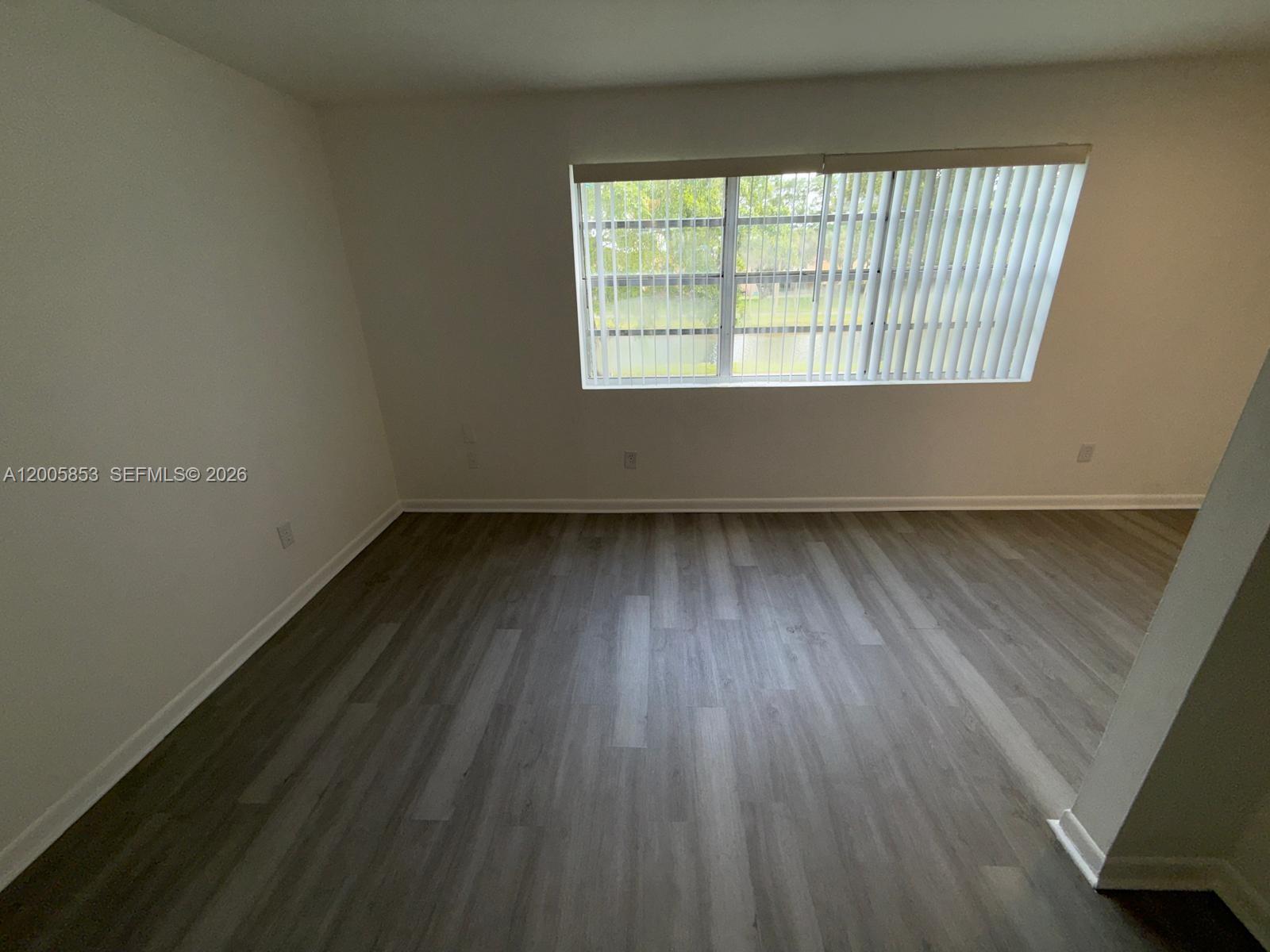 15285 Southwest 107th Lane, Unit 214 Miami, FL 33196 - Photo 5 of 16 an empty room with wooden floor and windows