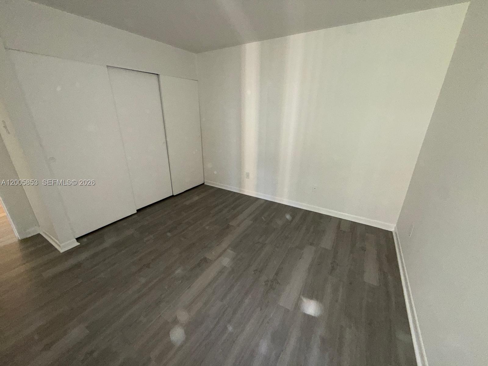 15285 Southwest 107th Lane, Unit 214 Miami, FL 33196 - Photo 8 of 16 a view of an empty room with wooden floor
