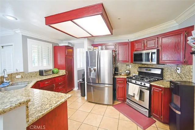 a kitchen with stainless steel appliances granite countertop a refrigerator stove and sink