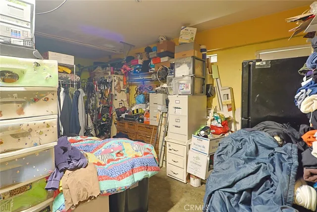 a utility room with fridge and bed