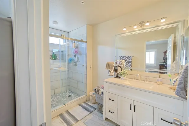 a bathroom with a granite countertop shower and a mirror