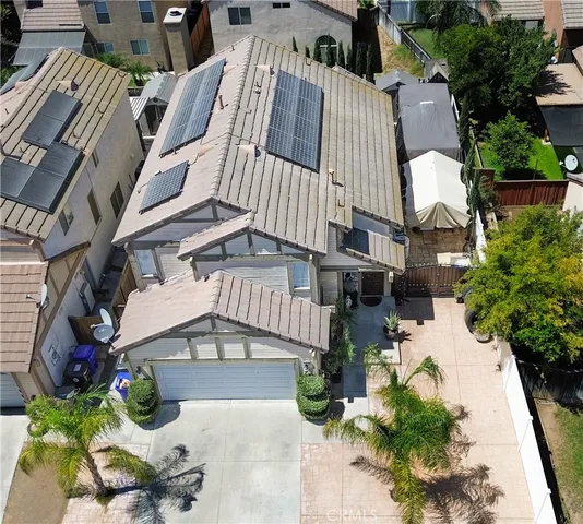 an aerial view of a house with large trees and flower plants