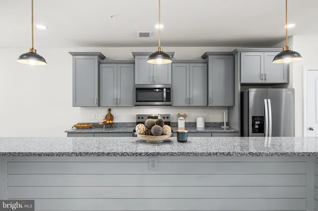 a kitchen with granite countertop a sink cabinets and stainless steel appliances