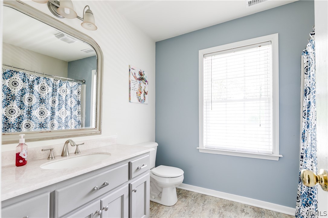10970 Weybridge Road Chester, VA 23831 - Photo 14 of 35 a bathroom with a toilet sink vanity and window