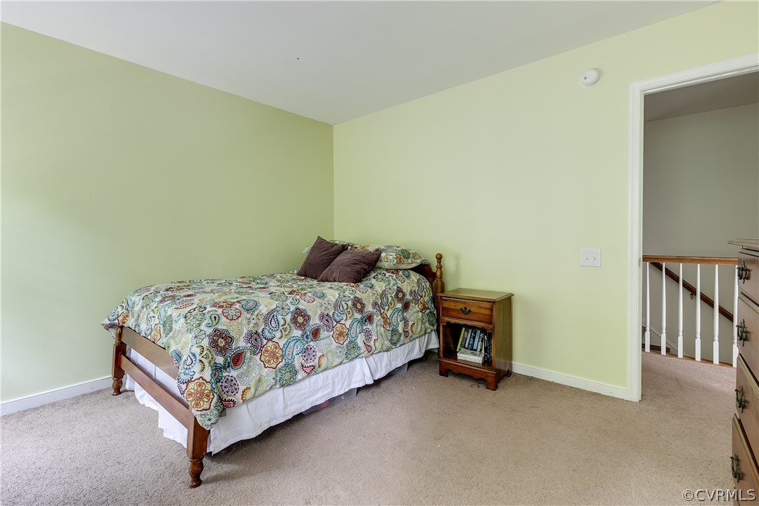 10970 Weybridge Road Chester, VA 23831 - Photo 16 of 35 a bed sitting in a room next to a lamp