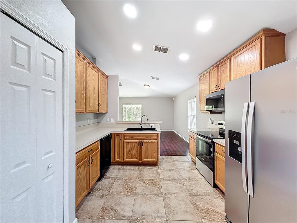 6358 Southwest 155th Place Ocala, FL 34473 - Photo 17 of 55 a large kitchen with stainless steel appliances granite countertop a stove top oven a sink and dishwasher