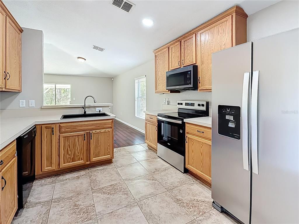 6358 Southwest 155th Place Ocala, FL 34473 - Photo 18 of 55 a kitchen with stainless steel appliances granite countertop a refrigerator sink and stove