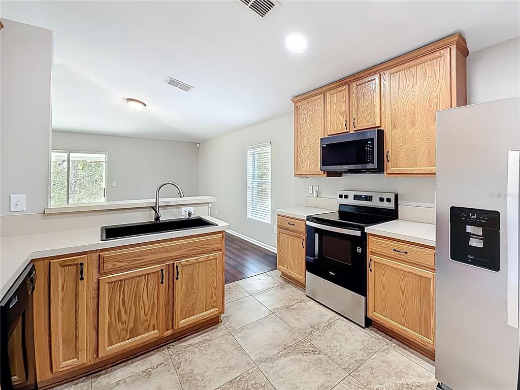 6358 Southwest 155th Place Ocala, FL 34473 - Photo 19 of 55 a kitchen with stainless steel appliances granite countertop a stove a sink and a microwave