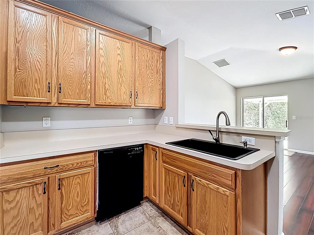 6358 Southwest 155th Place Ocala, FL 34473 - Photo 21 of 55 a kitchen with stainless steel appliances granite countertop a sink and a white cabinets