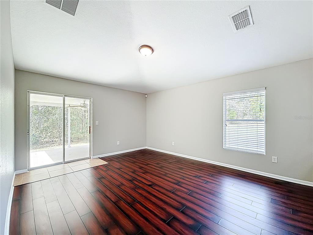 6358 Southwest 155th Place Ocala, FL 34473 - Photo 31 of 55 an empty room with wooden floor and windows