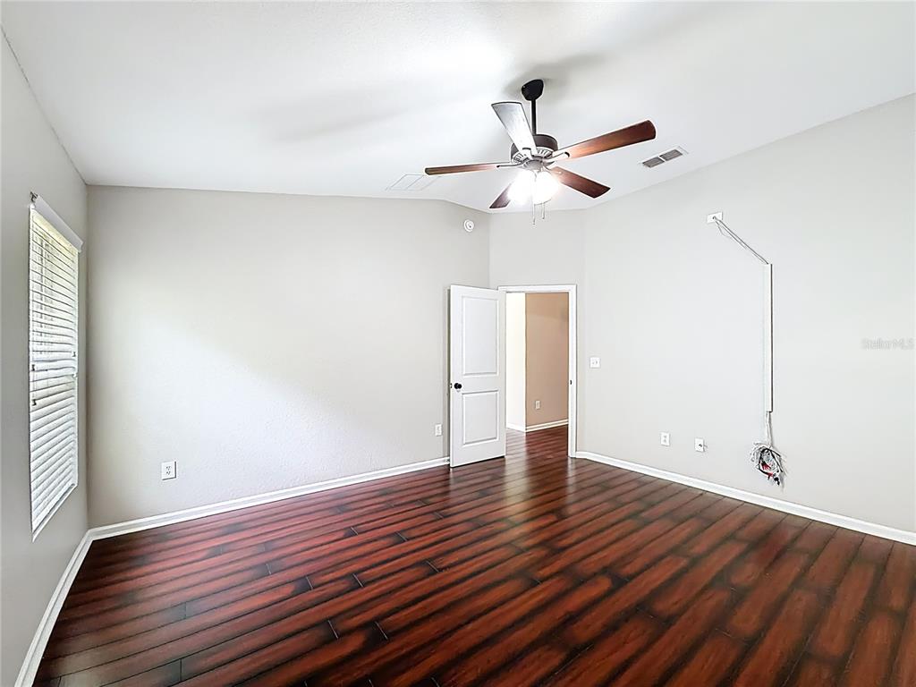 6358 Southwest 155th Place Ocala, FL 34473 - Photo 37 of 55 an empty room with wooden floor a ceiling fan and closet