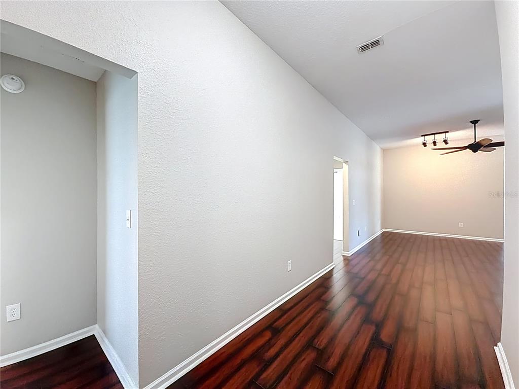 6358 Southwest 155th Place Ocala, FL 34473 - Photo 7 of 55 an empty room with wooden floor and windows