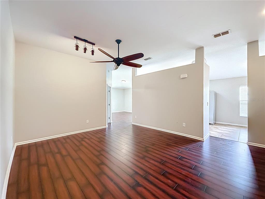 6358 Southwest 155th Place Ocala, FL 34473 - Photo 9 of 55 a view of a room with wooden floor a ceiling fan