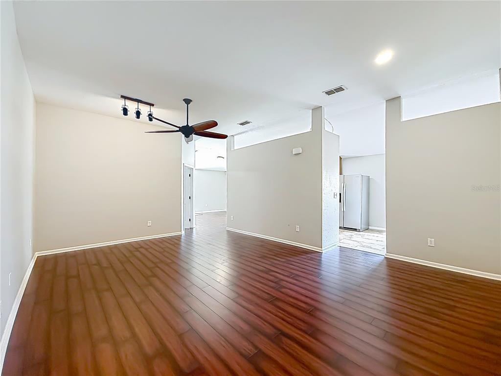 6358 Southwest 155th Place Ocala, FL 34473 - Photo 10 of 55 a view of a room with wooden floor a ceiling fan and staircase