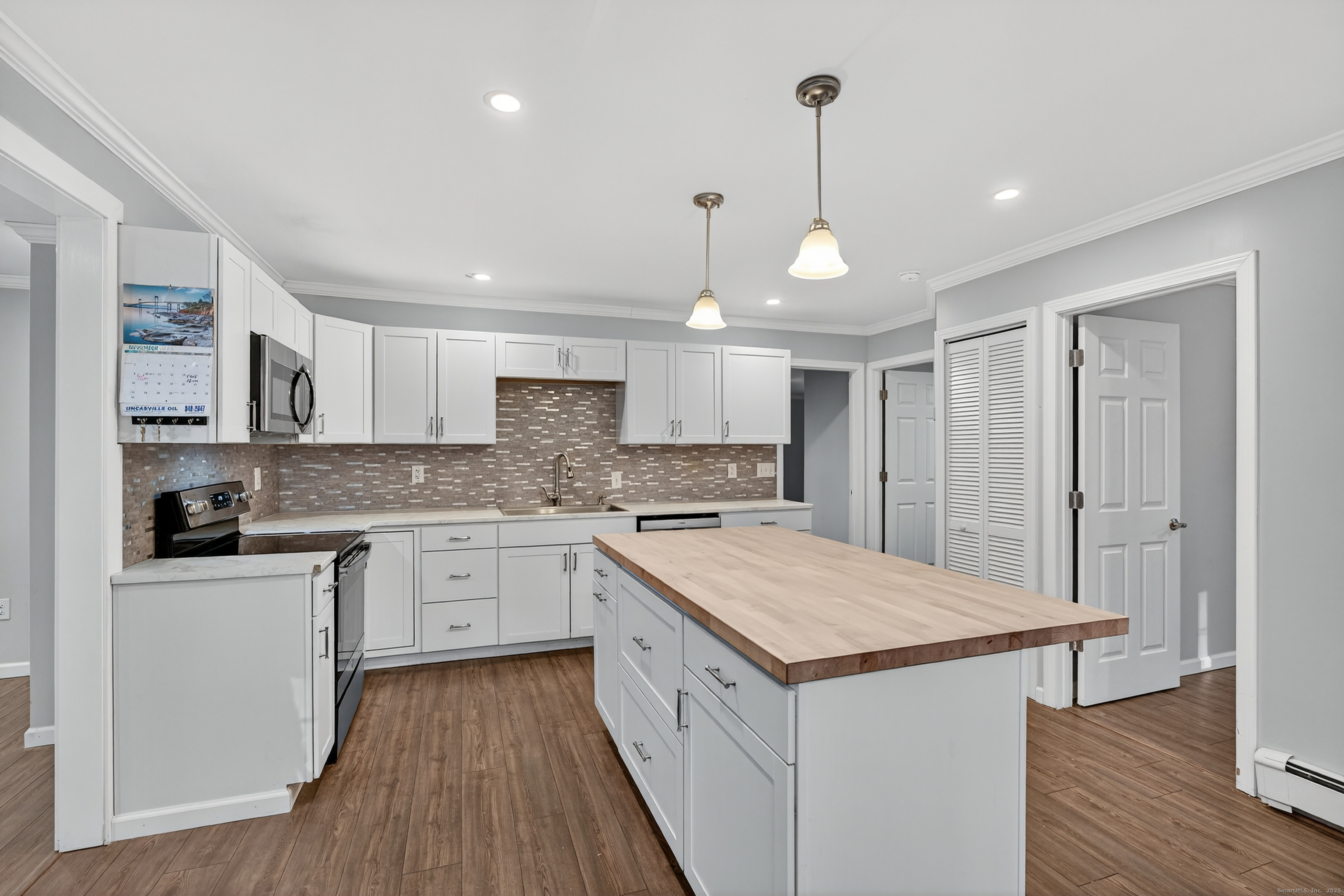 586 Back Road Windham, CT 06256 - Photo 6 of 32 a kitchen with white cabinets appliances and wooden floor