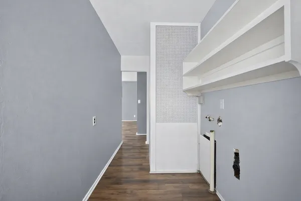 a view of a hallway with wooden floor and staircase