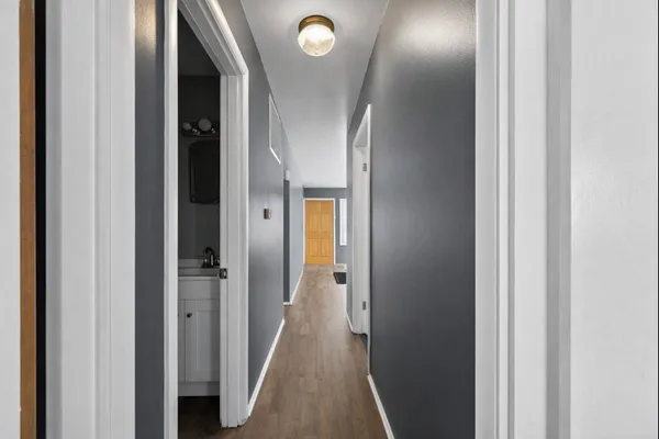 a view of a hallway with wooden floor
