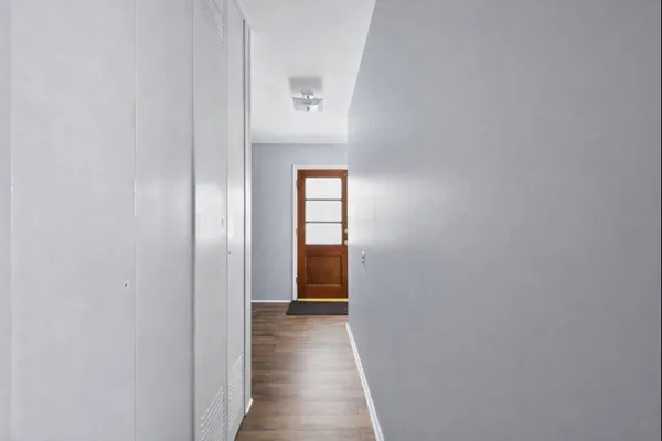 a view of a hallway with wooden floor
