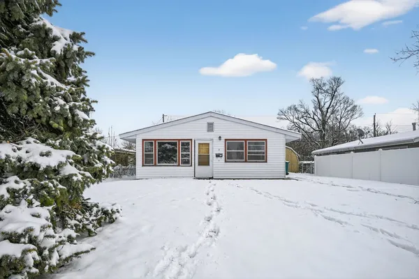 a front view of a house with a yard covered in snow
