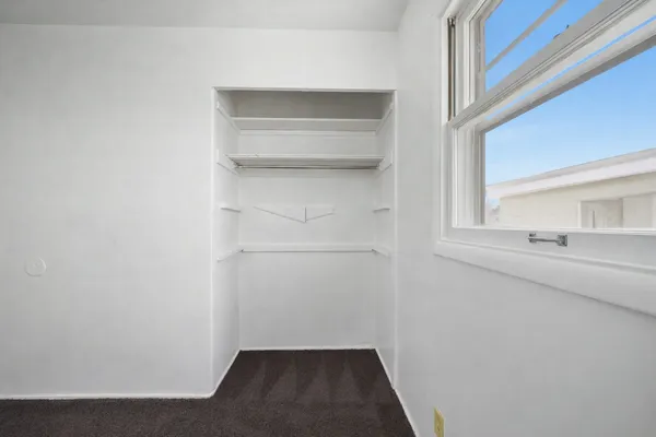 a view of walk in closet with empty racks