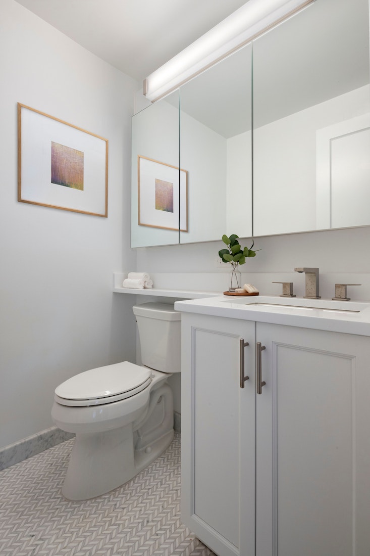 155 West 68th Street, Unit 30A Manhattan, NY 10023 - Photo 9 of 18 a bathroom with a sink toilet and mirror