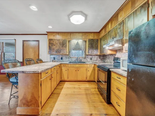 a large kitchen with stainless steel appliances granite countertop a sink and cabinets