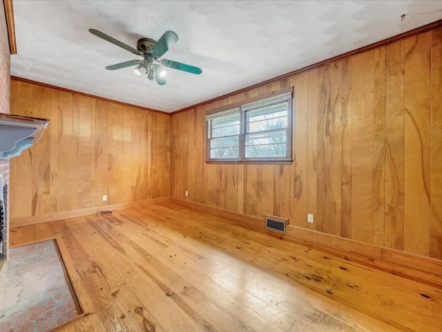 a view of an empty room with a fireplace and a window
