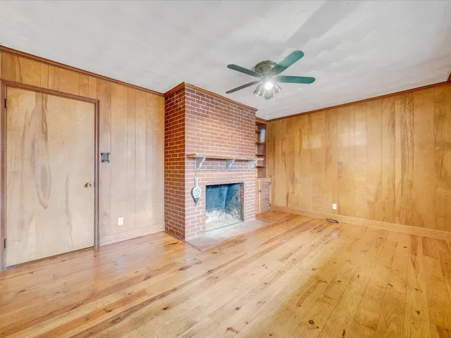 a view of an empty room with a window and fireplace