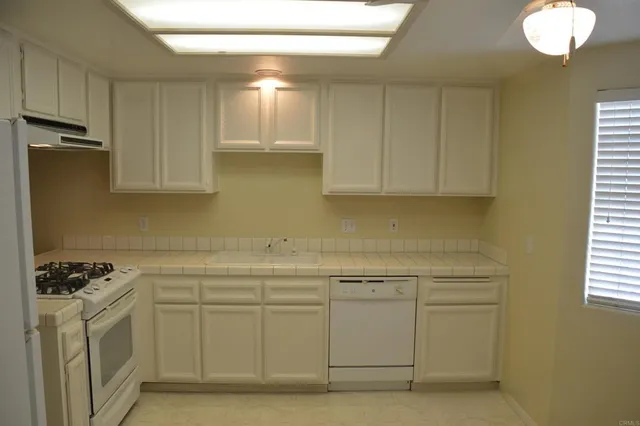 a kitchen with a sink cabinets and window