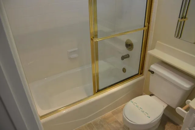 a bathroom with a toilet and a shower