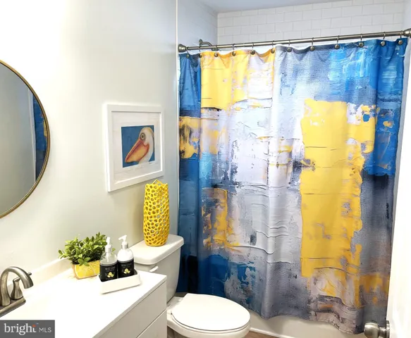 a white toilet sitting next to a bathroom sink and a shower