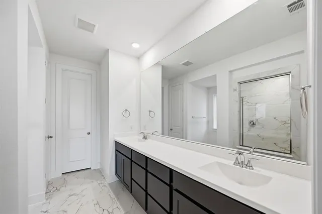 a bathroom with double vanity sinks and a mirror