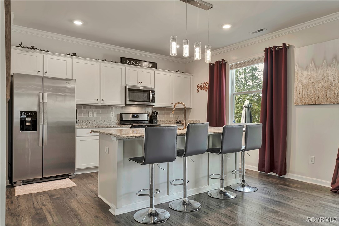 7232 Cress Terrace New Kent, VA 23124 - Photo 8 of 42 a kitchen with stainless steel appliances granite countertop a refrigerator a stove a sink and a dining table with wooden floor