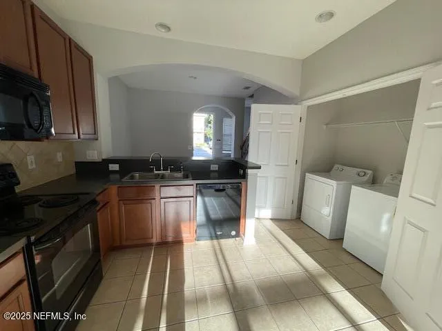 a kitchen with a sink a refrigerator and cabinets