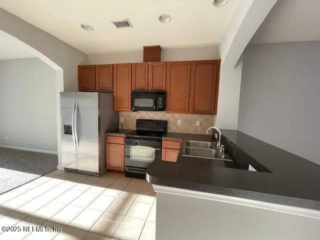a kitchen with stainless steel appliances a refrigerator sink and microwave