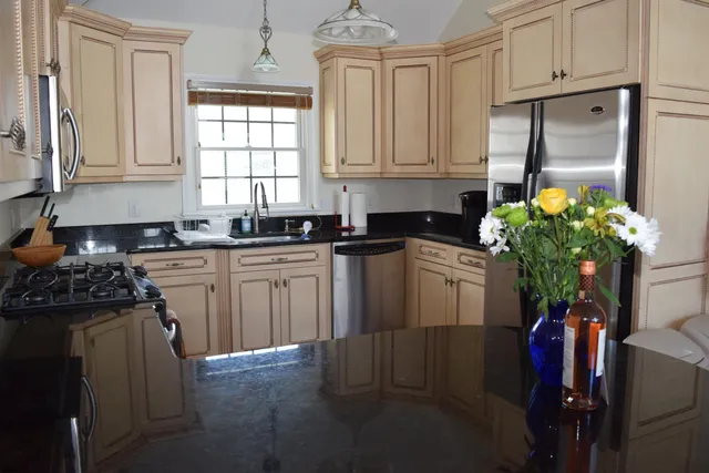 a kitchen with stainless steel appliances granite countertop a refrigerator sink and cabinets