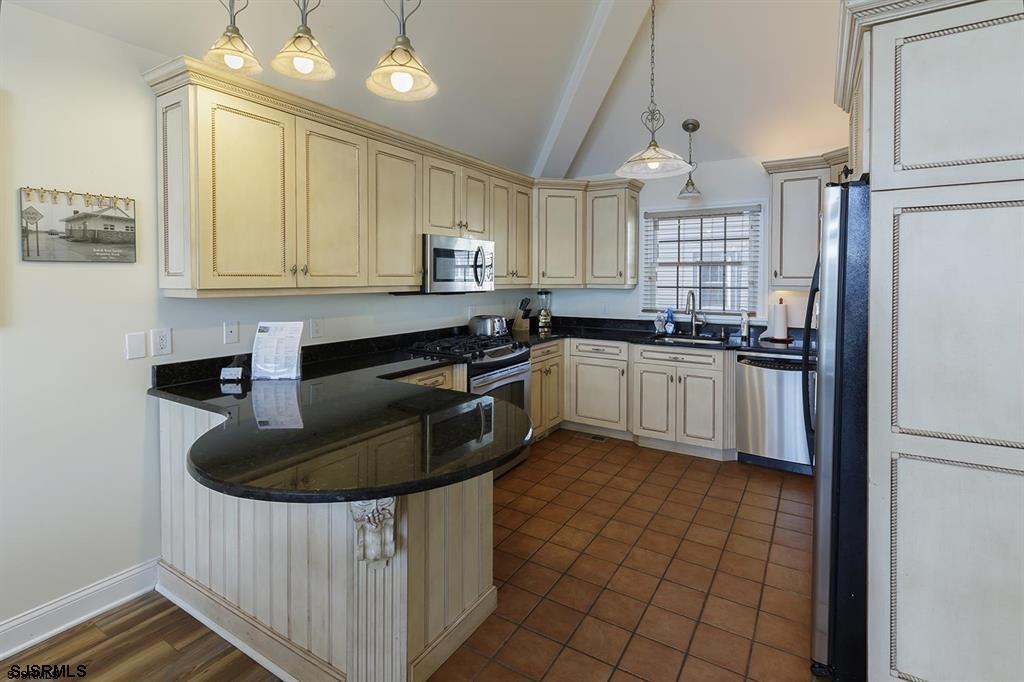 205 West Brigantine Avenue Brigantine, NJ 08203 - Photo 3 of 31 a kitchen with kitchen island granite countertop a sink a counter space appliances and cabinets