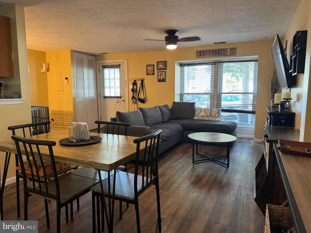 a living room with furniture a flat screen tv and a large window