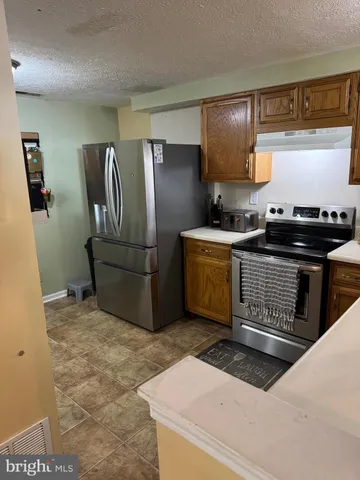 a kitchen with stainless steel appliances granite countertop a stove a refrigerator and a sink