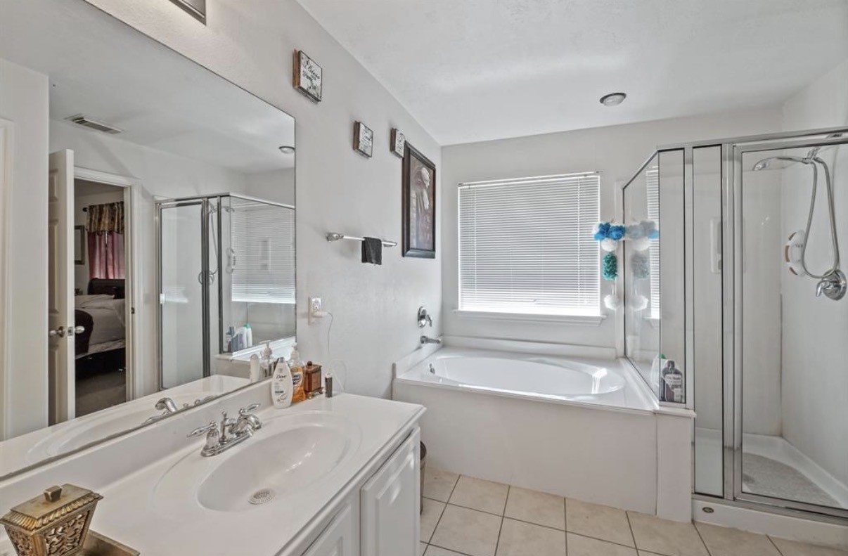 13134 Peppergate Lane Houston, TX 77044 - Photo 15 of 23 a bathroom with a tub sink shower and mirror