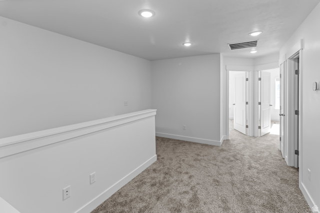 2995 South 265th Street West, Unit 752 Logan, UT 84321 - Photo 11 of 21 Carpeted hallway with white walls and trim, featuring recessed ceiling lights and multiple doorways