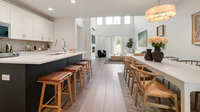 a kitchen with stainless steel appliances a table chairs in it and wooden floors