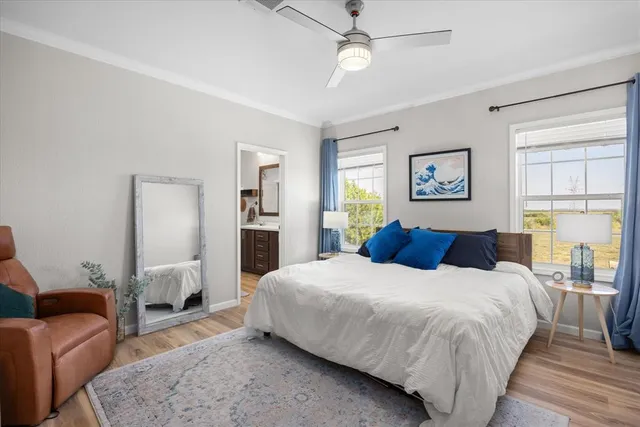 a bedroom with a bed wooden floor and window