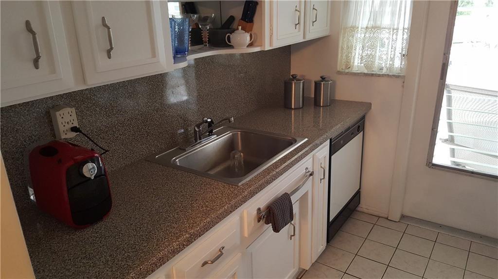 1110 North Riverside Drive, Unit 29 Pompano Beach, FL 33062 - Photo 11 of 17 a kitchen with a sink and cabinets