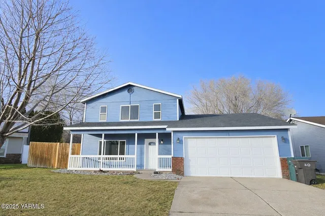 a front view of a house with a garden and yard