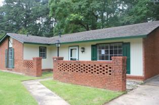 6241 Wares Ferry Road Montgomery, AL 36117 - Photo 1 of 1 a front view of a house with a garden