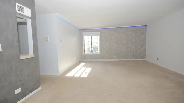 en empty room with wooden floor and ceiling fan