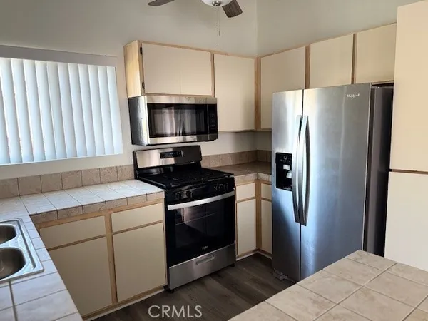 a kitchen with stainless steel appliances granite countertop a refrigerator stove and microwave